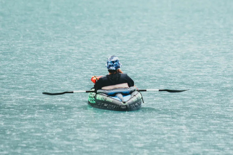 Persona remando en kayak sobre el agua turquesa de un lago glaciario
