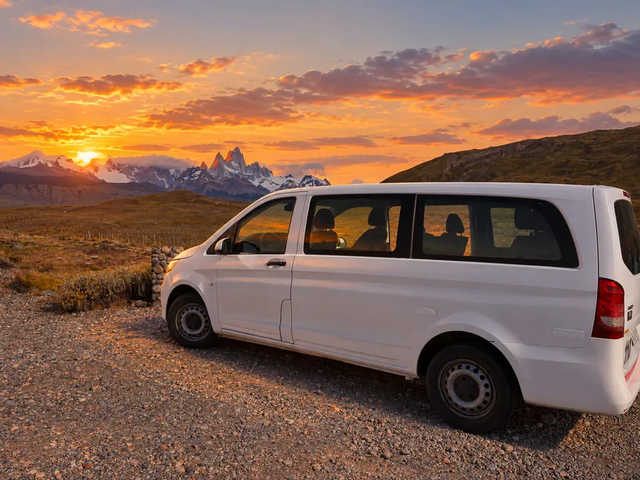 Combi de traslado privado estacionada frente al Fitz Roy al atardecer